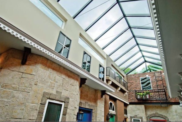 Glazed atrium roof over a stone courtyard